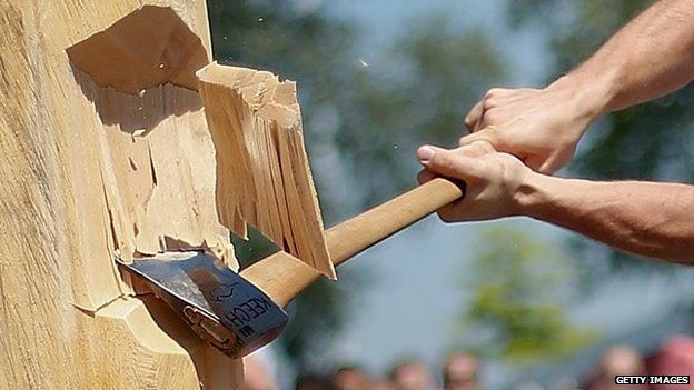 A man takes part in a Basque Country sports competition on cutting wood with an axe