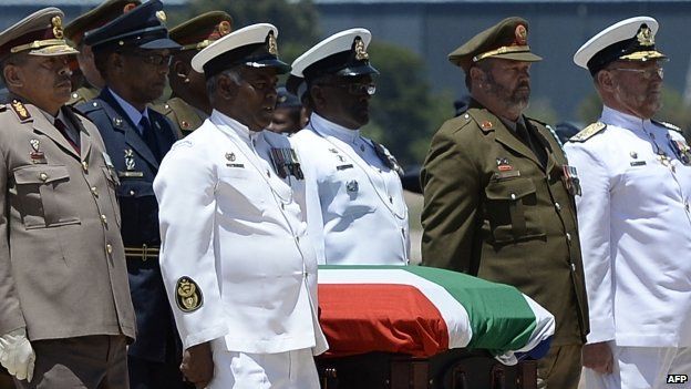 Officers carry Nelson Mandela's coffin on to a C130 military transport plane
