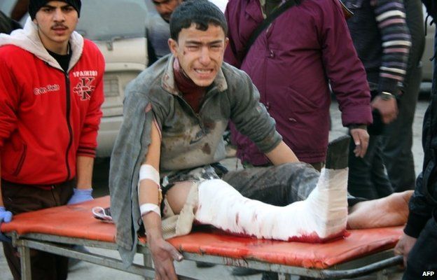 An injured youth on a stretcher in Aleppo's Maadi district (17 December 2013)