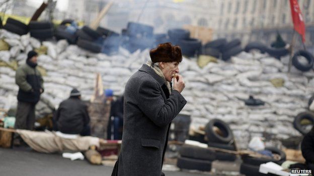 A pro-European integration protester eats a sandwich near a barricade during a rally in Independence Square in Kiev, December 16, 2013