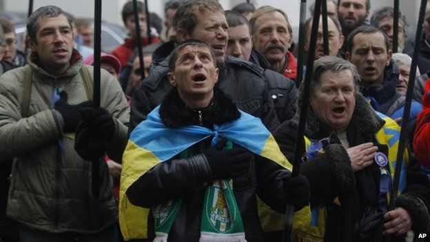 Pro-European Union activists sing the national anthem during a rally outside the office of the richest man of Ukraine Rinat Akhmetov during an anti-government protest in Kiev, Ukraine, Wednesday, Dec. 18, 2013.