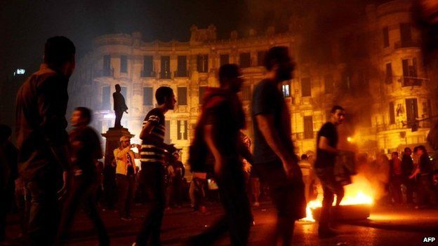 Egyptian protesters set fire to wood at Talaat Harb Square in Cairo at a protest against military trials for civilians (26 November 2013)