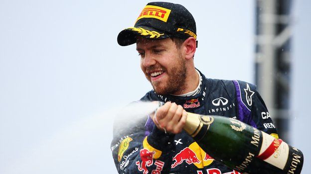 Sebastian Vettel of Germany and Red Bull Racing celebrates on the podium after winning the Brazilian Formula One Grand Prix 2013.