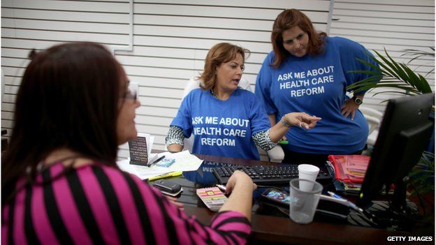 Ines Leyva talks to insurance agents with Sunshine Life and Health Advisors, as she looks to purchase an insurance policy under the Affordable Care Act in Hialeah, Florida (November 14, 2013)
