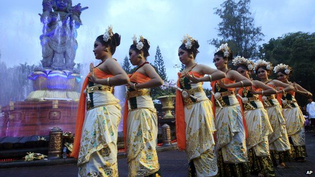 Women in traditional costumes danced during a parade for 2013's last sundown on Bali, Indonesia