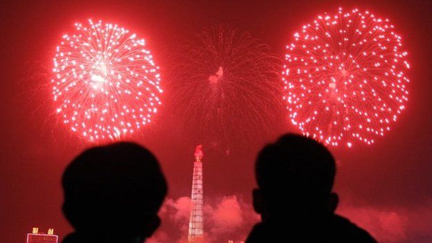 Fireworks explode over Juche Tower and the Taedong River in Pyongyang