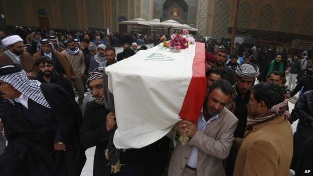 Mourners in the Shia holy city of Najaf hold the coffin of a soldier killed in the city of Ramadi (30 December 2013)