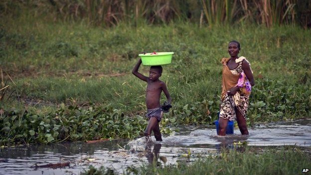 Displaced people who fled the recent fighting between government and rebel forces in Bor by boat across the White Nile, bathe, wash clothes and gather water from the Nile in the town of Awerial, South Sudan Wednesday, Jan. 1, 2014.