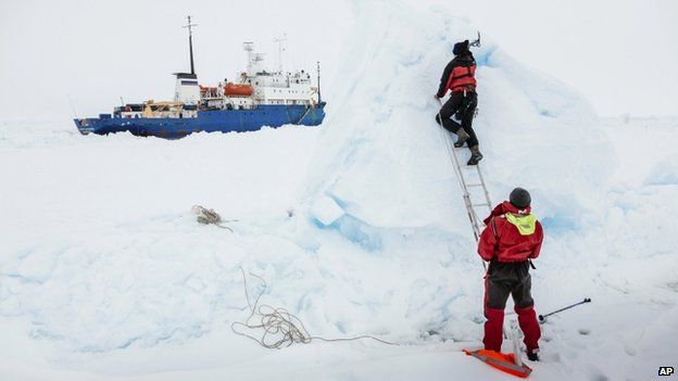 Ben Maddison and Ben Fisk from the Russian ship MV Akademik Shokalskiy work to place a wind indicator atop an ice feature near the trapped ship 1,500 nautical miles south of Hobart, Australia, 31 December 2013