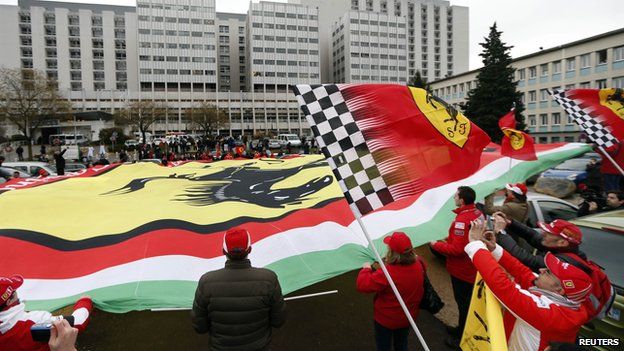 Ferrari fans from France, Italy and Germany display a giant Ferrari flag as they attend a silent 45th birthday tribute to seven-times former Formula One world champion Michael Schumacher (3 Jan 2014)