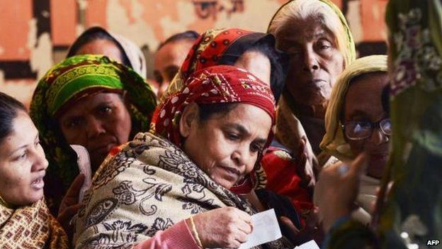 Voters check registration documents at a Dhaka polling station, 5 Jan