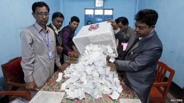 A polling officer pours ballot papers from a box onto a table to count during parliamentary elections in Dhaka January 5, 2014.