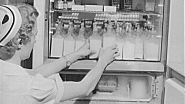 A nurse arranges formula bottles in 1942