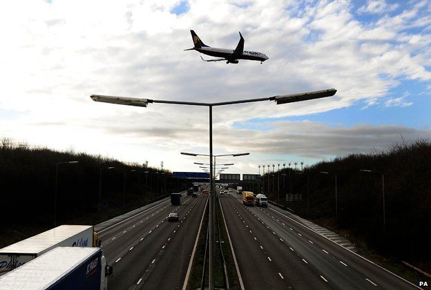 A plane coming in to land at East Midlands Airport over the M1