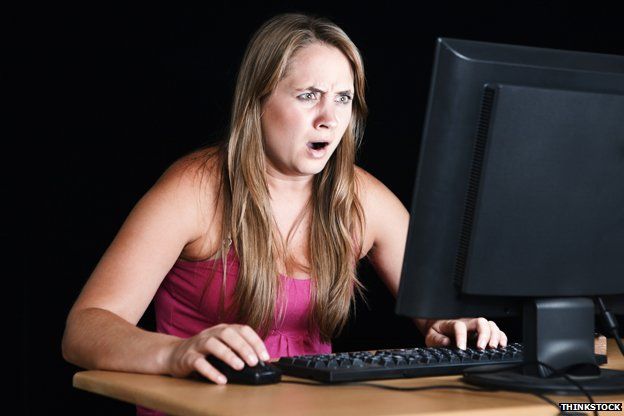 Woman looks shocked at what's on the computer