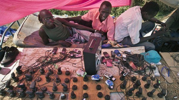 Men running a makeshift mobile phone charging station at a camp for displaced people in South Sudan