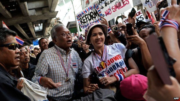 Thai protest leader Suthep Thaugsuban poses for a picture with a supporter as anti-government protesters march through downtown Bangkok on 15 January 2014