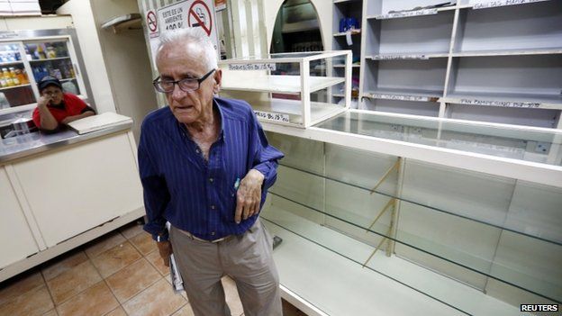 A man reacts after he found all shelves empty at a bakery in Caracas on 14 January, 2014