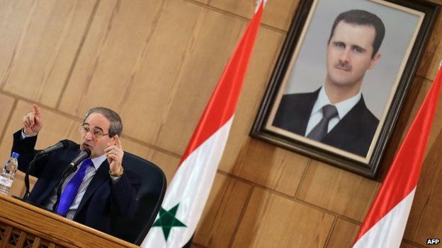 Syrian Deputy Foreign Minister Faisal Mekdad addresses reporters in front of a portrait of Bashar al-Assad (4 November 2013)