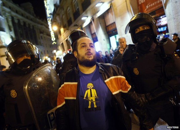 Riot police detain a Burgos solidarity protester in Madrid, 16 January