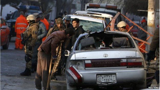 Fawad, a worker of a Lebanese restaurant who was injured during a suicide bombing attack outside the restaurant, looks at a damaged vehicle near the restaurant in Kabul, January 18