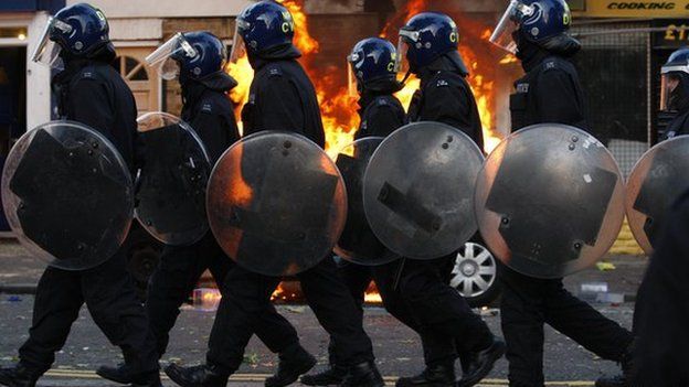 LONDON, ENGLAND - AUGUST 08: Riot police walk along Clarence Road in Hackney on August 8, 2011 in London, England