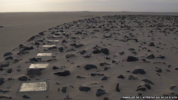 broken mirrors around a black stone circle in the sand