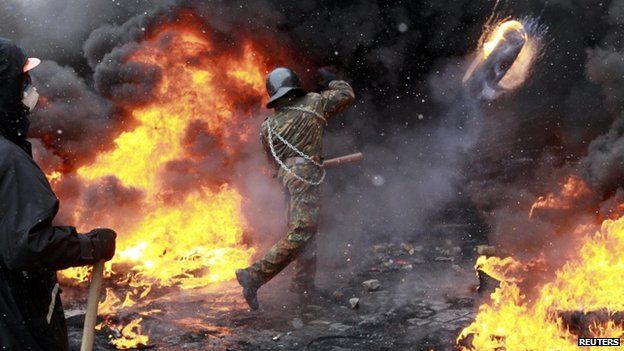 Protester throws burning tyre in Kiev (22 January 2014)