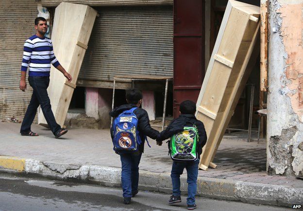 Children outside a coffin-maker's shop in central Baghdad