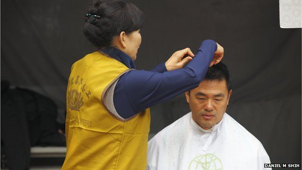 A volunteer cuts a man's hair at a Tzu Chi event on 18 January 2014