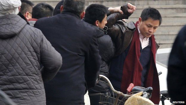 Zhang Xuezhong (right), a lawyer for Zhao Changqing, argues with plain-clothed policemen as he refuses to show them his identification card when he was stopped and questioned by them on his way to court to attend Mr Zhao's trial in Beijing, 23 January 2014