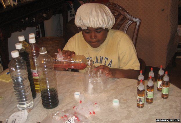 Leanna Archer sitting at a table mixing hair products, 2007