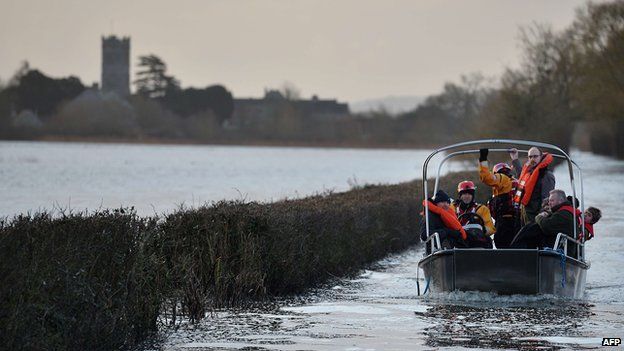 Residents are transported by boat over flood water at the cut-off village of Muchelney in Somerset, southwestern England, on January 27, 2014