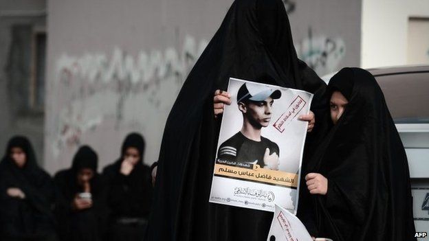 A woman holds up a picture of Fadel Abbas during his funeral in the Bahraini village of Diraz (26 January 2014)