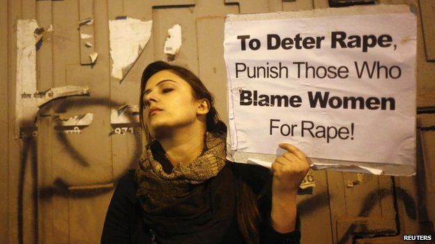 A demonstrator holds a placard as she attends a candlelight vigil to mark the first anniversary of Delhi gang rape, in New Delhi December 16, 2013.