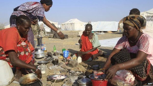 South Sudanese refugees cook on an open fire at a camp run by the Sudanese Red Crescent