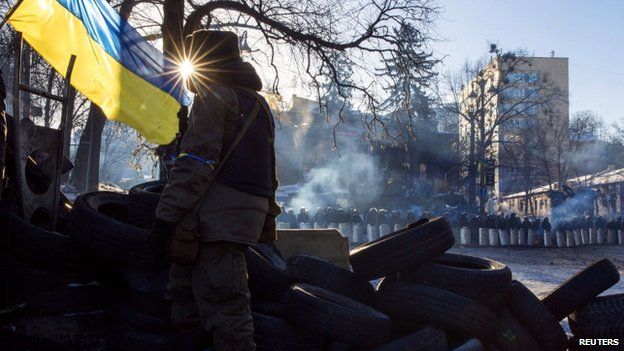 An anti-government protester stands on a barricade in Kiev, 3 February 2014