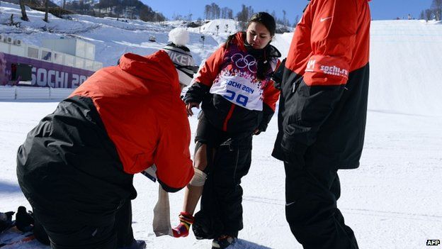 A trainer wraps a bandage around with Julia Marinos' leg during a training session at the Rosa Khutor Extreme Park on 5 February, 2014