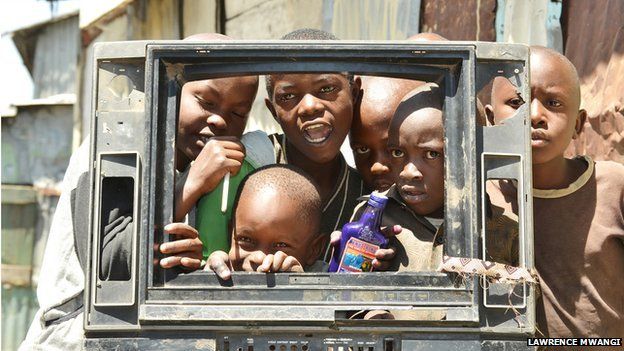 Children peeking through a broken TV set, copyright Lawrence Mwangi