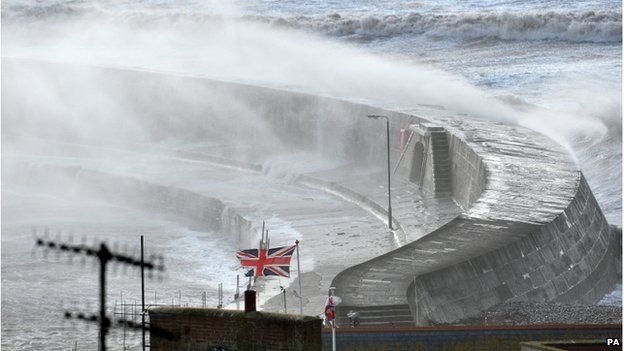 Waves crash over a sea wall