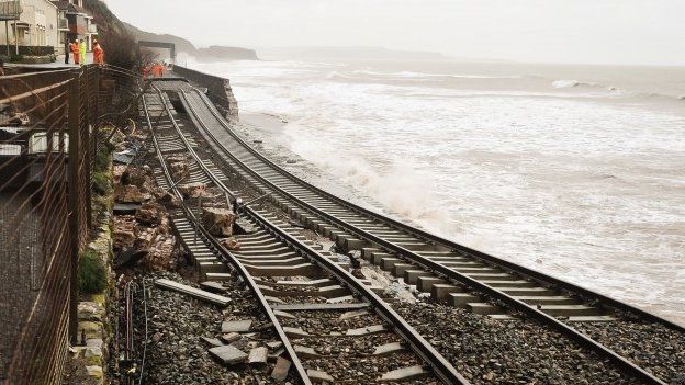 A huge length of railway track is exposed and left hanging after the sea wall collapsed in Dawlish