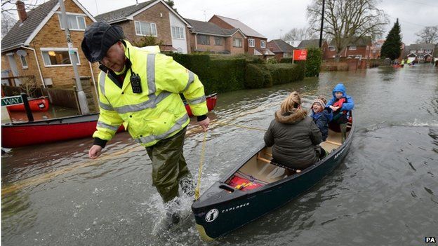 A volunteer helps ferry residents of Purley on Thames, Berkshire