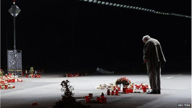 On 3 September 2010, a man stands in front of candles and flowers in the tunnel in which 21 people died during the 2010 Love Parade music festival.