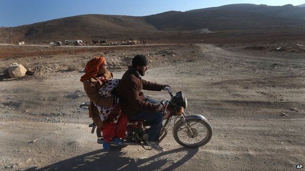 A Syrian man with his wife and child ride a motorcycle as they flee from Yabroud, the last rebel stronghold in Syria's mountainous Qalamoun region, on their way to the Lebanese-Syrian border town of Arssal, in eastern Lebanon, on Wednesday