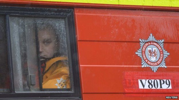 A member of Devon and Somerset Fire and Rescue Service looks out through the rain in his vehicle in the village of Thorney on the Somerset Levels