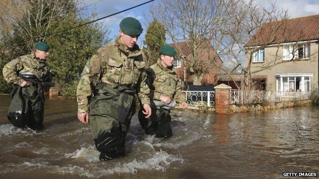 Royal Marines from 40 Commando wade past flooded properties in Moorland