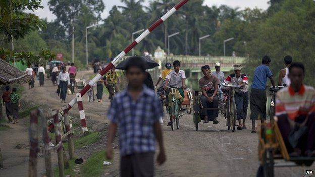 In this 14 September 2013 photo, Muslims travel past a road barrier next to a security checkpoint in Maungdaw, northern Rakhine state, Myanmar