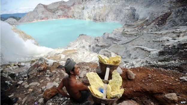 This photo taken on 1 February 2014 shows a miner carrying blocks of sulphur from Ijen crater in Banyuwangi, East Java