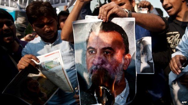 In this photograph taken on November 22, 2013, protesters burn a photograph of Tarun Tejpal, in New Delhi.