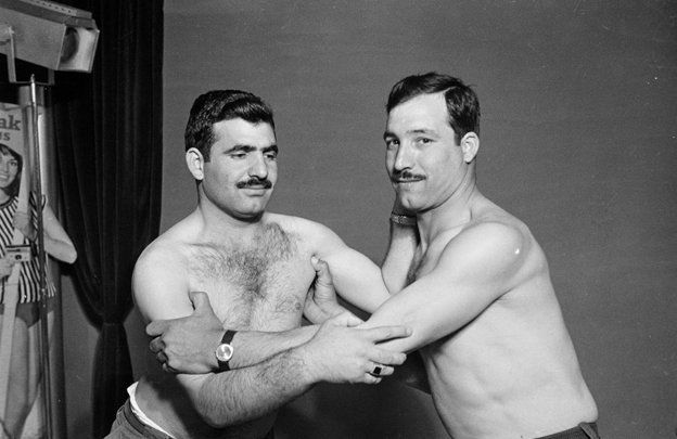 two men wrestle with their shirts off